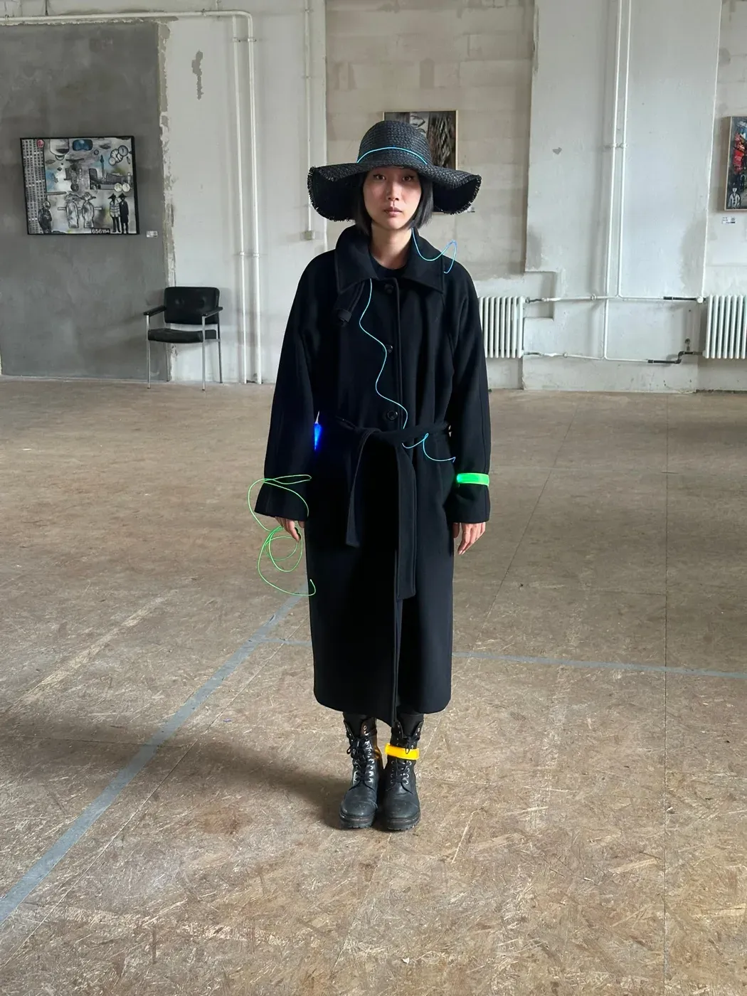 A time traveller in a black coat and woven hat during a performance